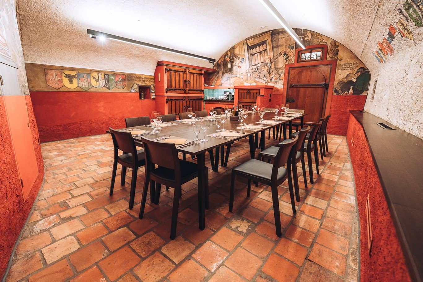 Der Staatskeller Schaffhausen mit seinen Fresken an der Wand ist mit einem Tisch und St&uuml;hlen ausgestattet, die f&uuml;r ein Bankett bereit stehen